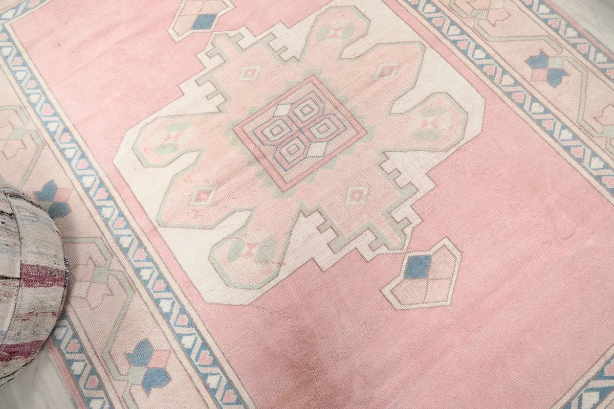 Angled view highlighting the soft pink color and central geometric medallion.