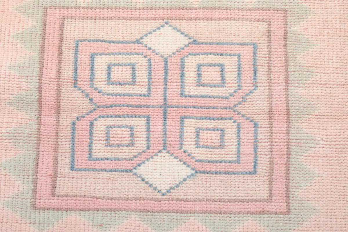 Extreme close-up of the intricate central motif within the medallion, showing knotting.
