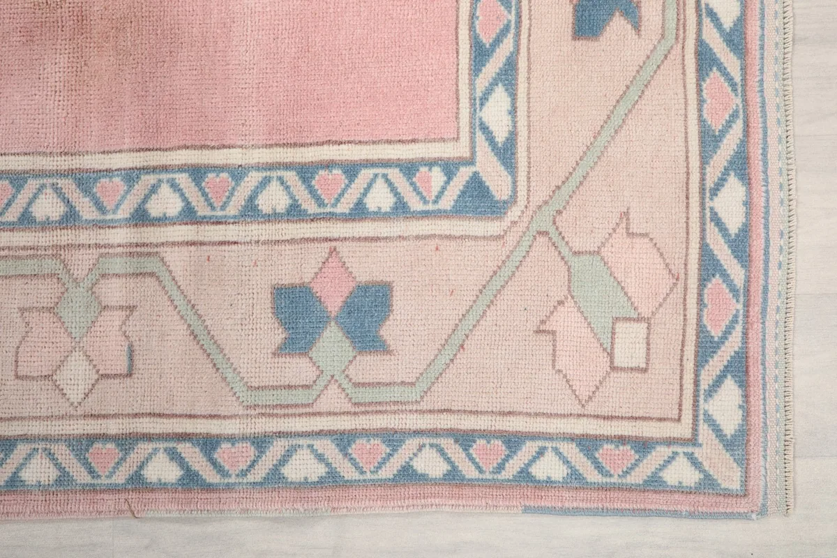 Detailed view of the corner border design with blue and cream geometric motifs.
