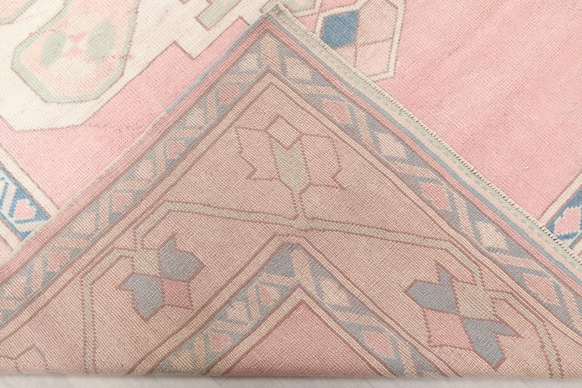 View of the underside of the rug, showing the hand-knotted cotton foundation.
