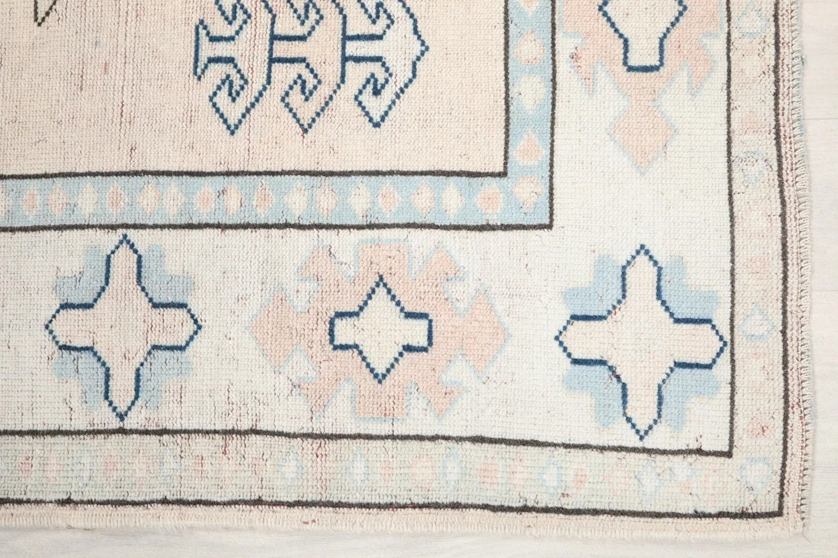 Detailed view of the border and field patterns, showing blue and rose geometric shapes