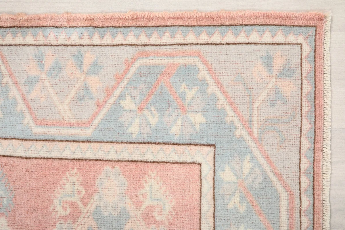 Detailed view of the blue border with geometric patterns and rose outer edge