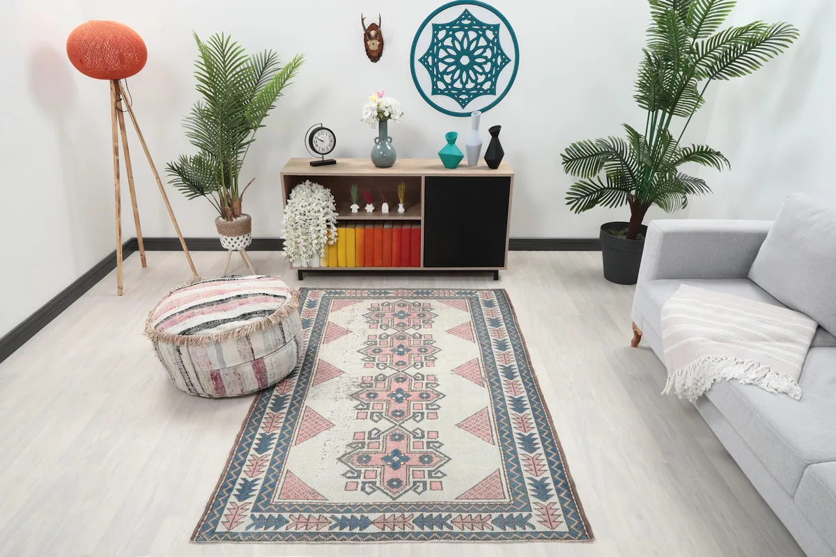 Vintage Anatolian rug displayed in a living room setting with a light gray sofa and wooden cabinet