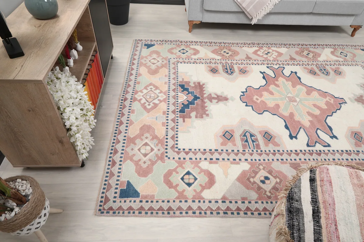 Ivory Rose Geometric Anatolian Rug in a room, showing its placement relative to a sofa and cabinet