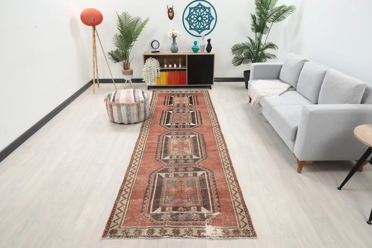 Long view of the rust runner rug in a modern living space with a gray sofa.