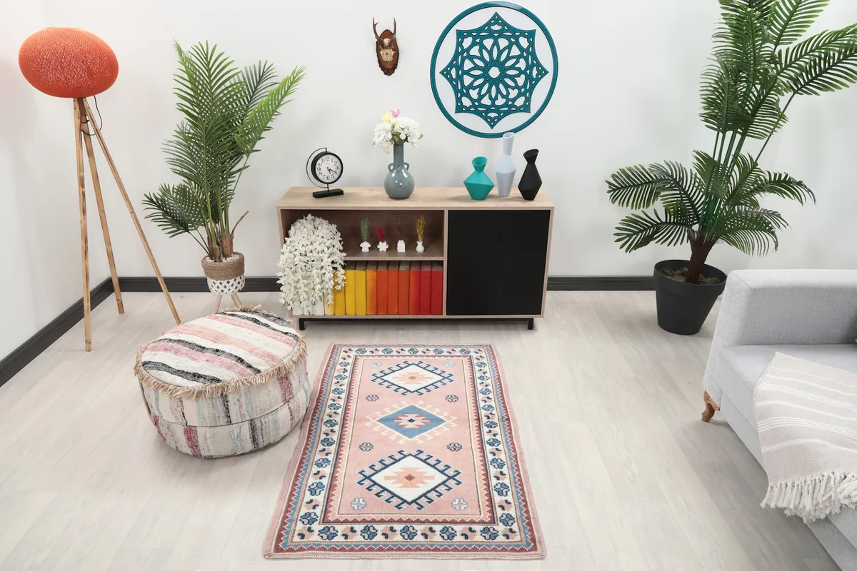 Pink geometric rug shown in a modern living space with light colored furniture