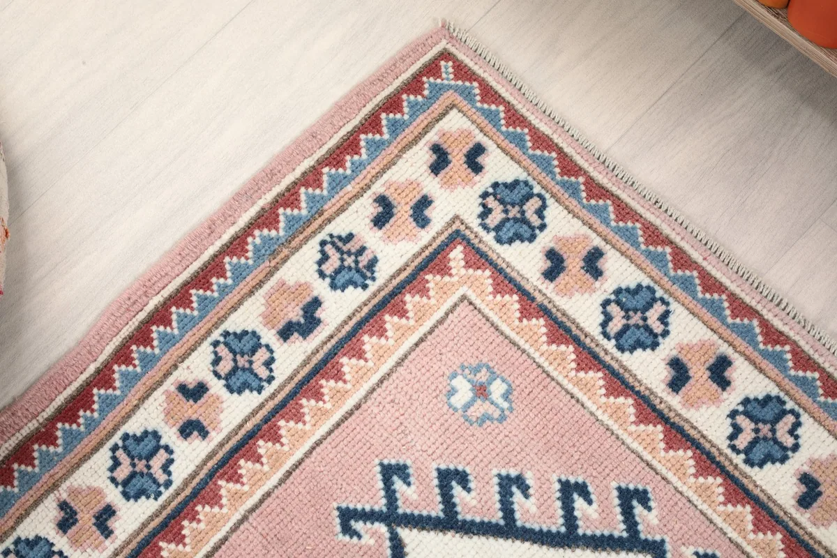 Corner detail of the rug's border, featuring intricate patterns and color transitions