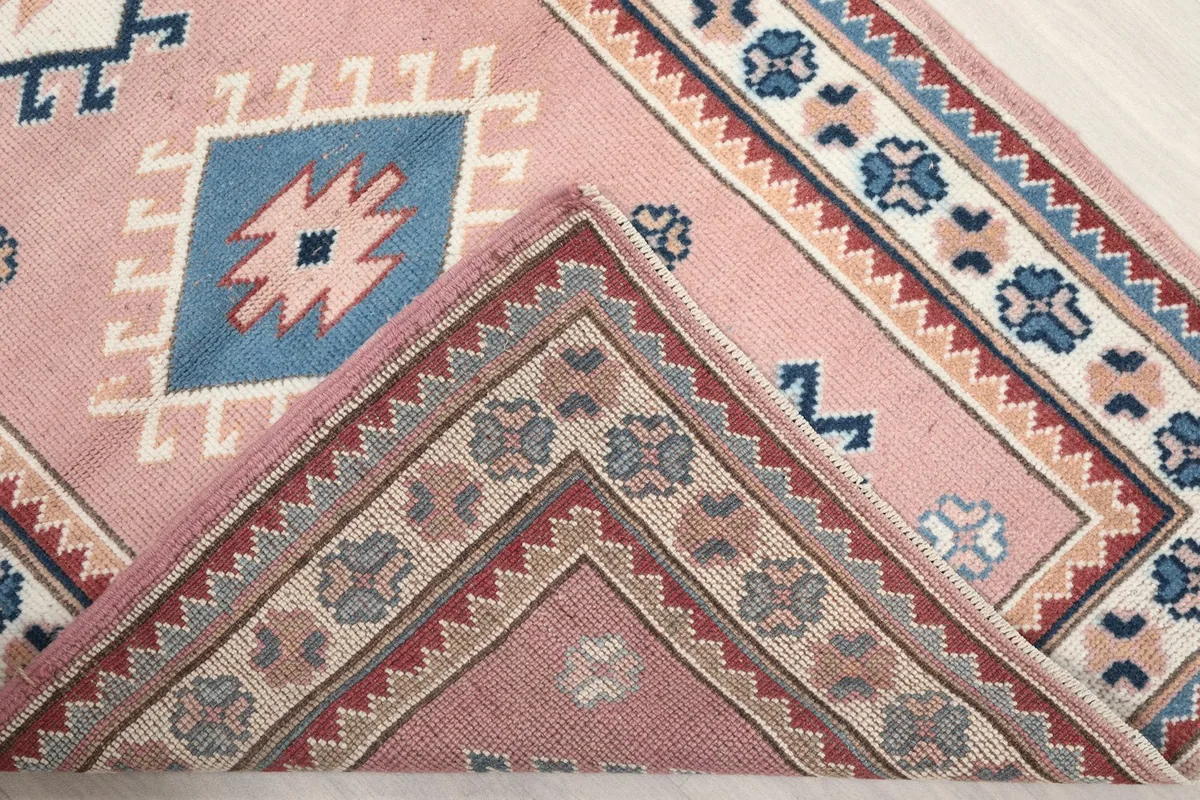 Rug corner folded back, revealing the hand-knotted wool pile and cotton foundation
