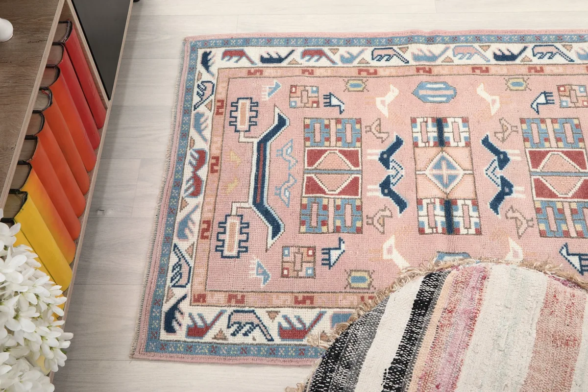 High-angle shot of the rose rug on the floor, capturing the overall pattern and color variations.