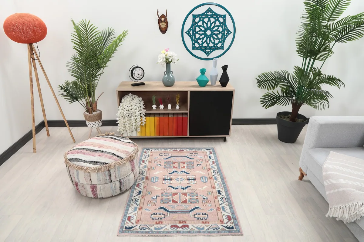 Rose tribal rug in a living room setting with modern furniture and plants, showing its scale.