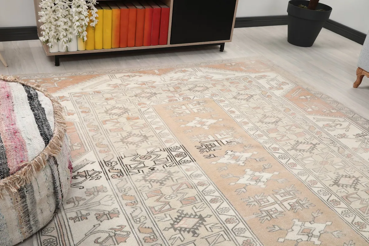 Close-up of the rug's central rose field and ivory border with tribal motifs