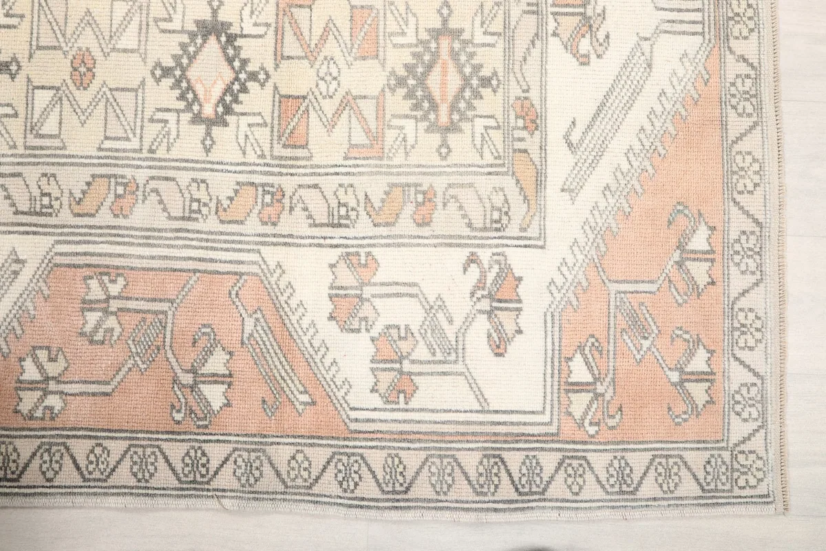 Detailed view of the rug's corner showing the rose field and patterned ivory border