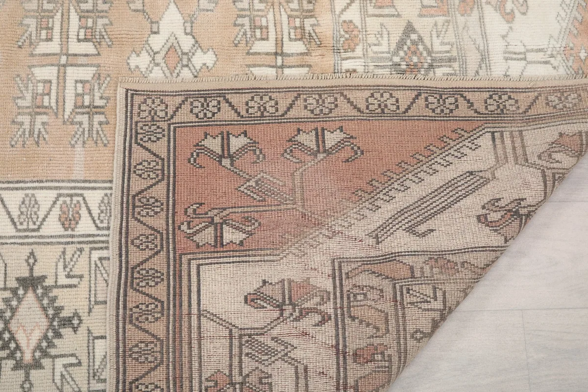 Close-up of the rug's edge, showing the back of the rug and the short fringe