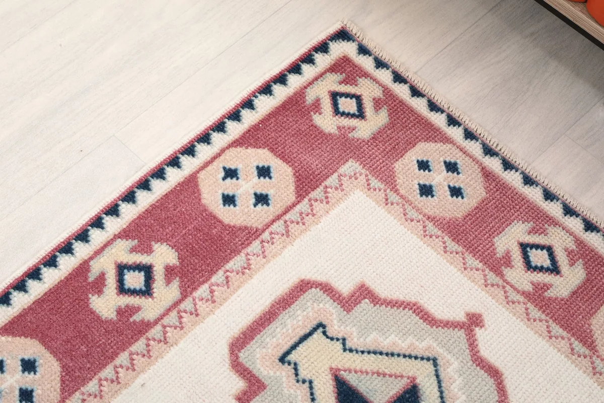 Corner detail of the rug, showing the border design and the transition to the main field.