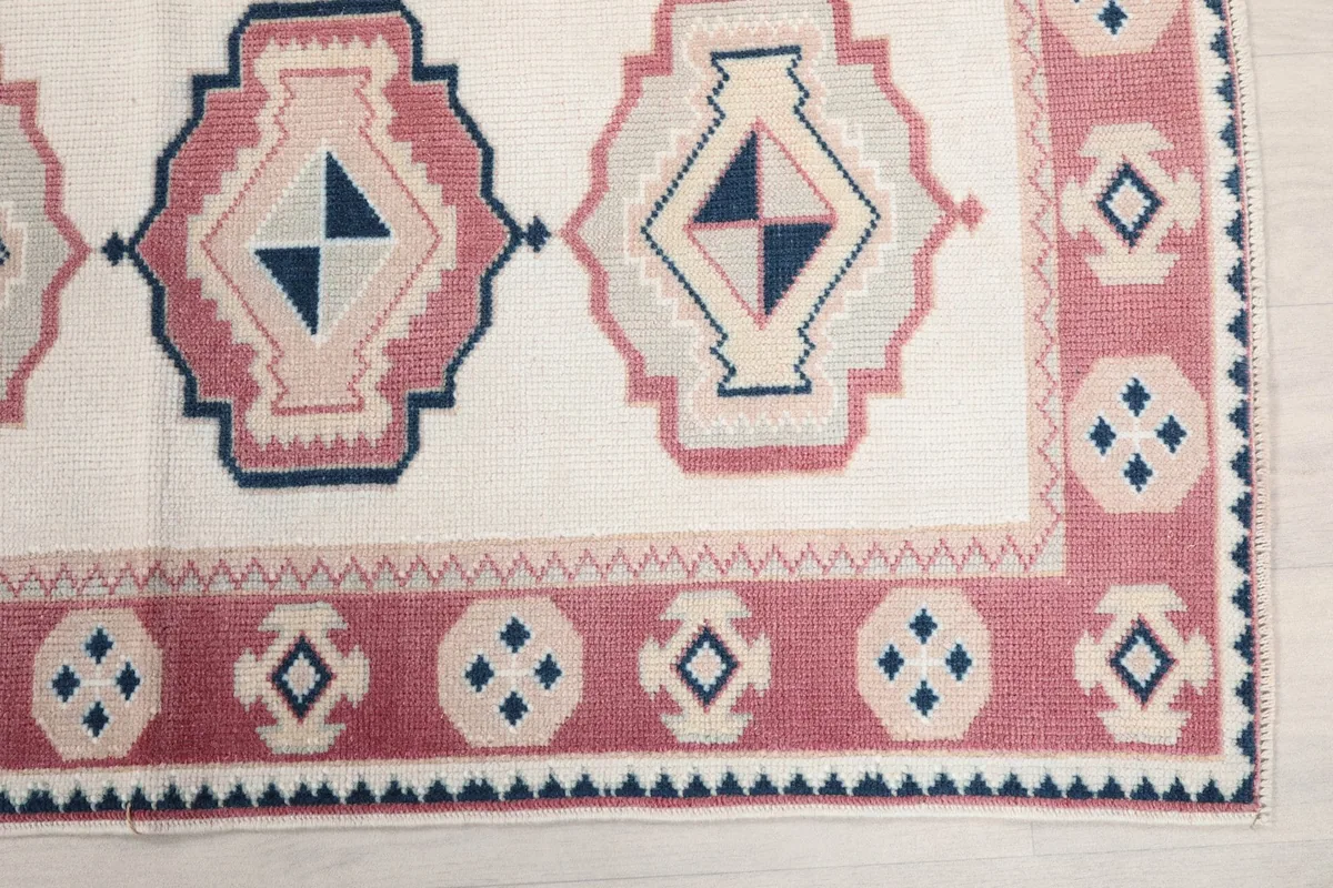 Detail of the rose border with small geometric motifs and a corner of the main field.