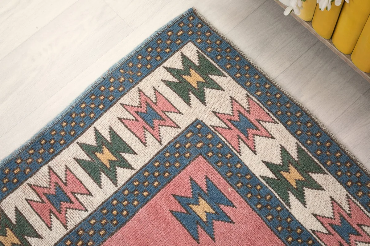 Detailed shot of the rug's border design, featuring geometric shapes in various colors