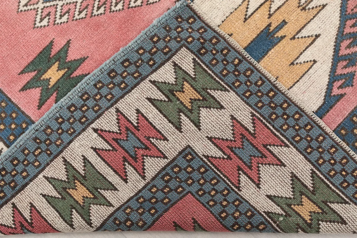 Folded corner of the rug revealing the hand-knotted cotton foundation and wool pile