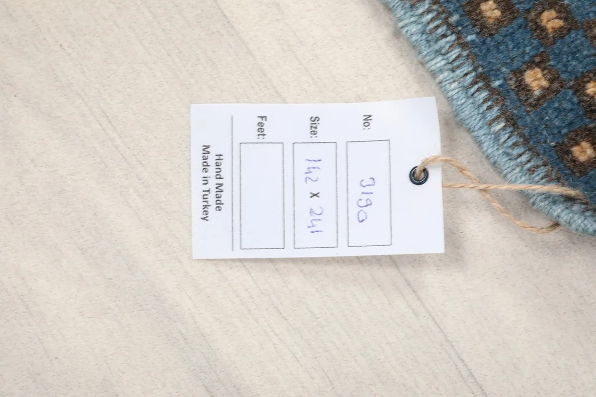 Product tag indicating the rug's size 142 x 241 cm and 'Hand Made in Turkey'