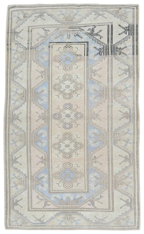 Full overhead view of the 4x7 vintage cream and blue tribal rug on a white background.