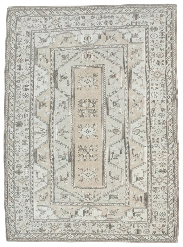 Full overhead view of the beige and gray tribal medallion rug on a white background
