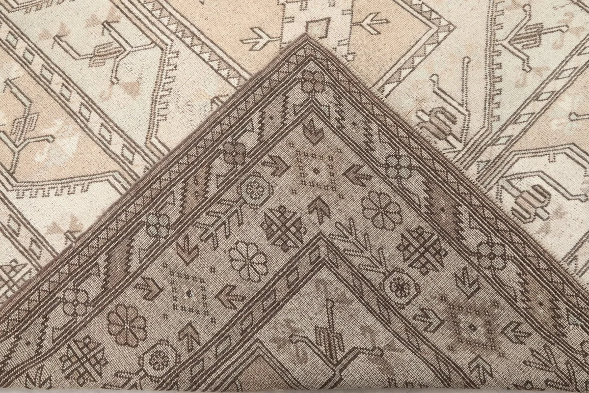View of the back of the hand-knotted rug, revealing its cotton foundation and knotting