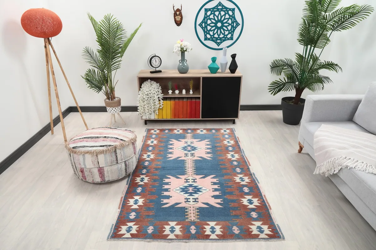 Room view showing the blue and rust vintage rug complementing a modern living space with light furniture.