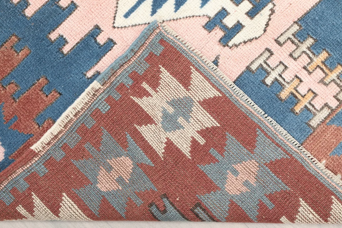 View of the back of the hand-knotted rug, revealing the cotton foundation and knotting structure.