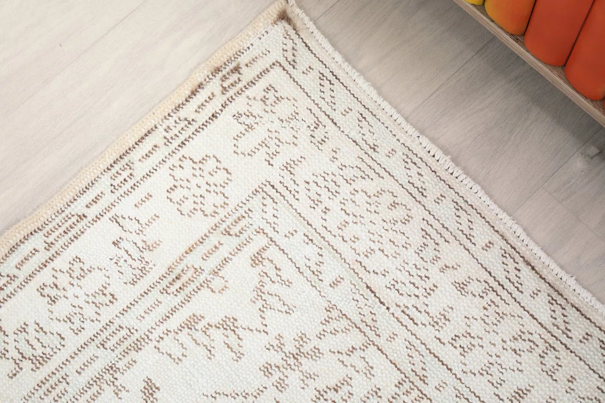 Angled view of the rug's border and field design, showing the subtle color variations
