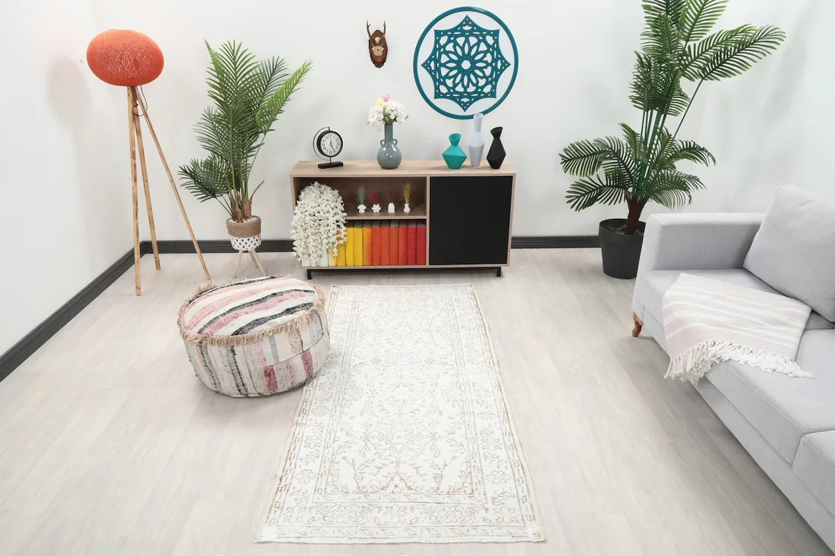 Ivory and beige runner rug in a modern living space with light wood floors and grey sofa