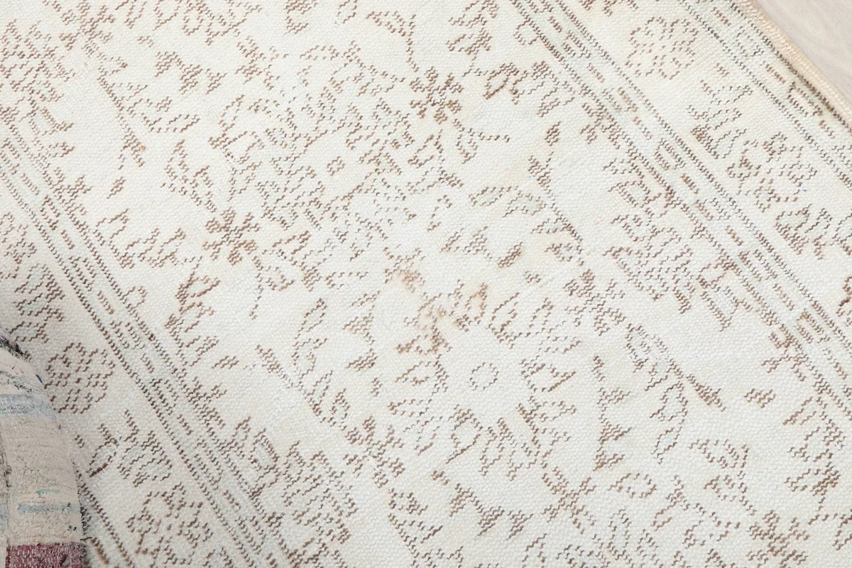 Overhead detail of the rug's central design, highlighting the intricate beige motifs