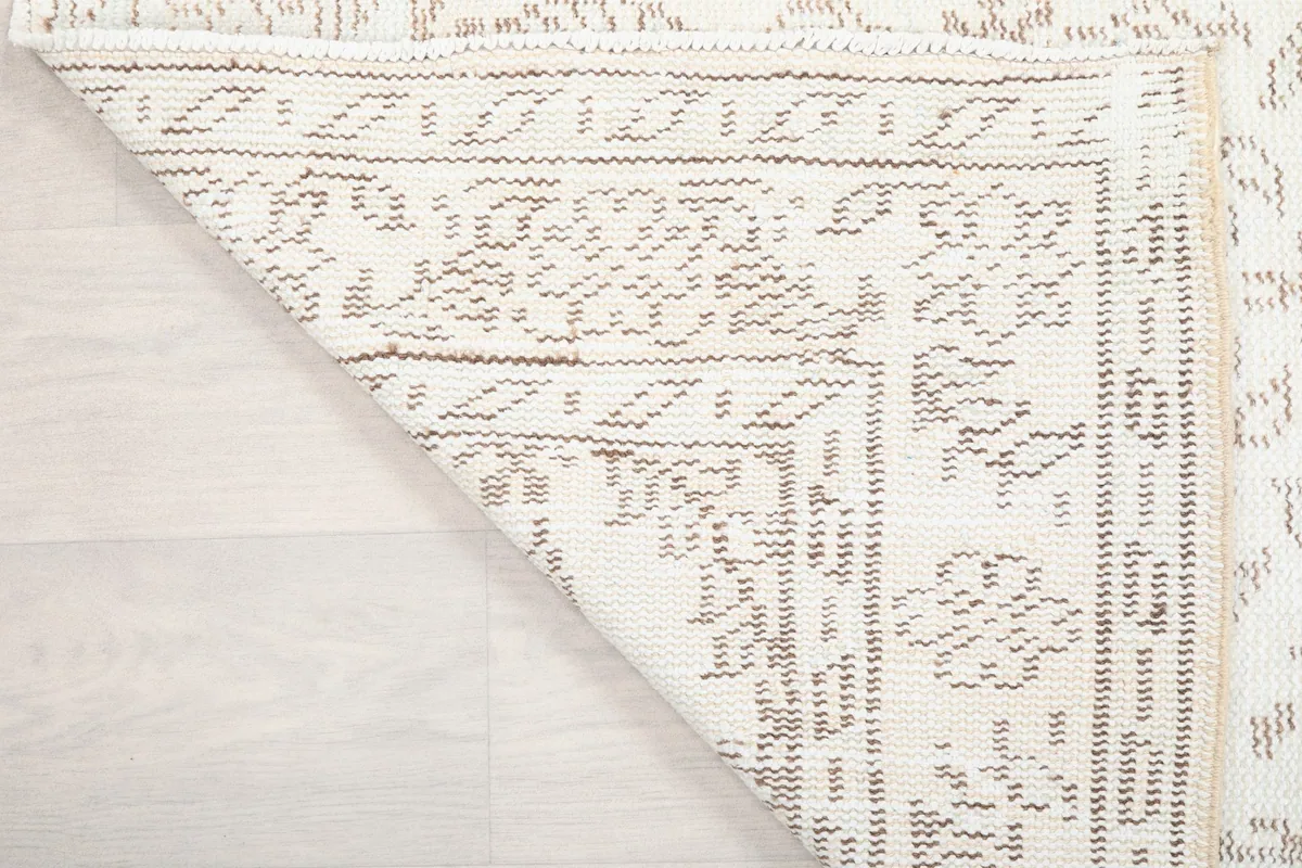 Another folded corner view, showing the rug's construction and the reverse side of the pattern