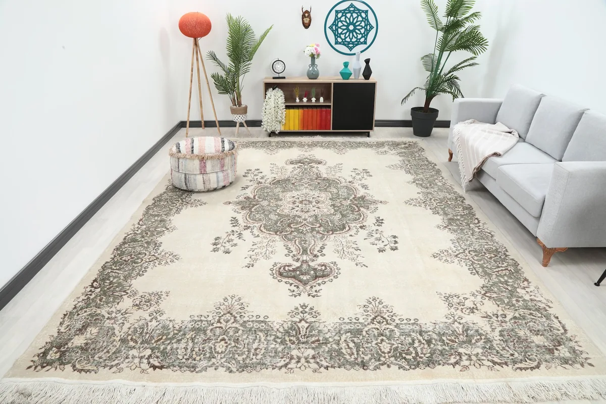 Oversized ivory rug grounding a modern living room with a gray sofa and various decor items.
