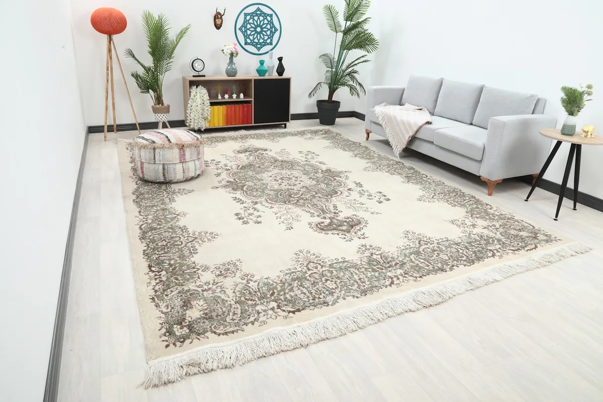 Angle view of the large ivory rug in a living room setting, showing its scale relative to furniture.