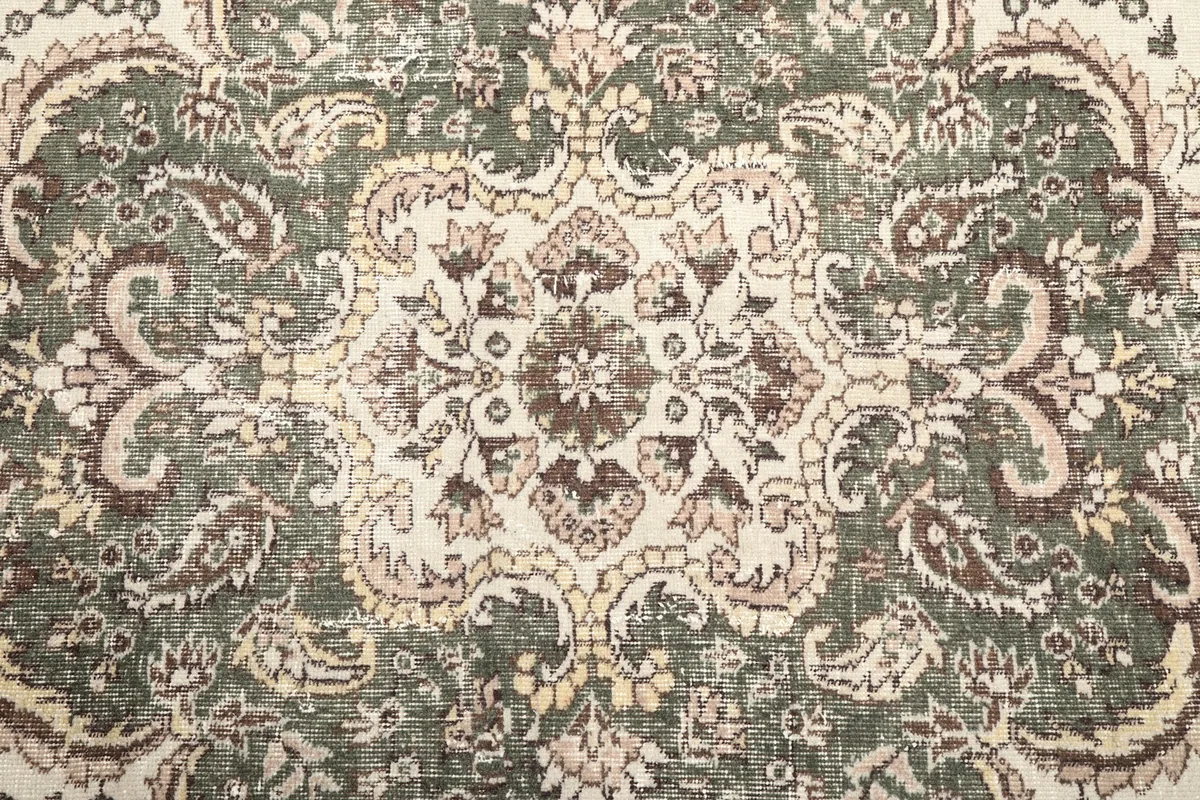 Extreme close-up of the medallion's center, revealing the hand-knotted texture and color variations.