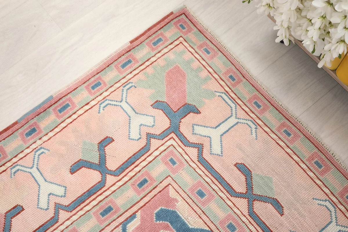 Corner detail of the rug, showing the intricate geometric patterns and color transitions