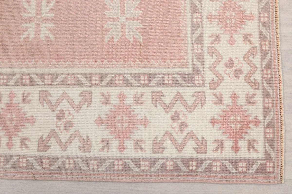 Corner detail of the rug's border and main field with geometric motifs