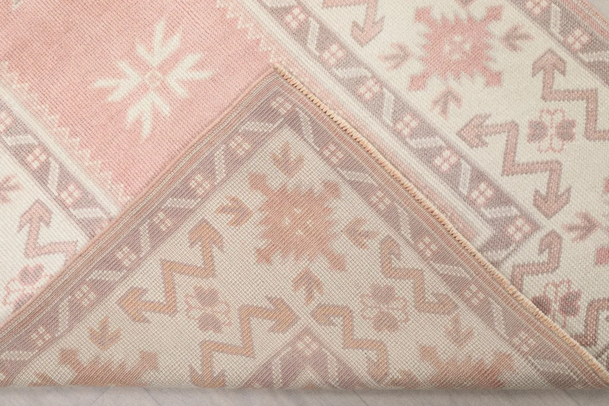 Folded corner of the rug revealing the hand-knotted construction on the back