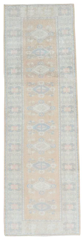 Full top view of the vintage tan tribal geometric runner rug on a white background
