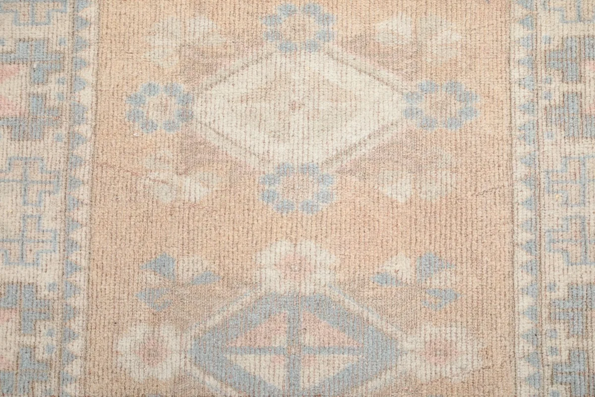 Close-up of the rug's center showing individual geometric diamond and floral-like patterns