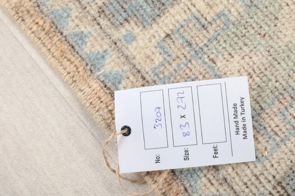 Close-up of the product tag indicating the rug's size, origin, and hand-made quality