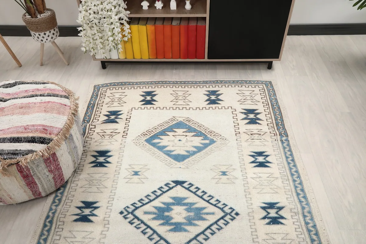 View of the ivory and blue rug in a room, capturing its overall presence and design within the decor.