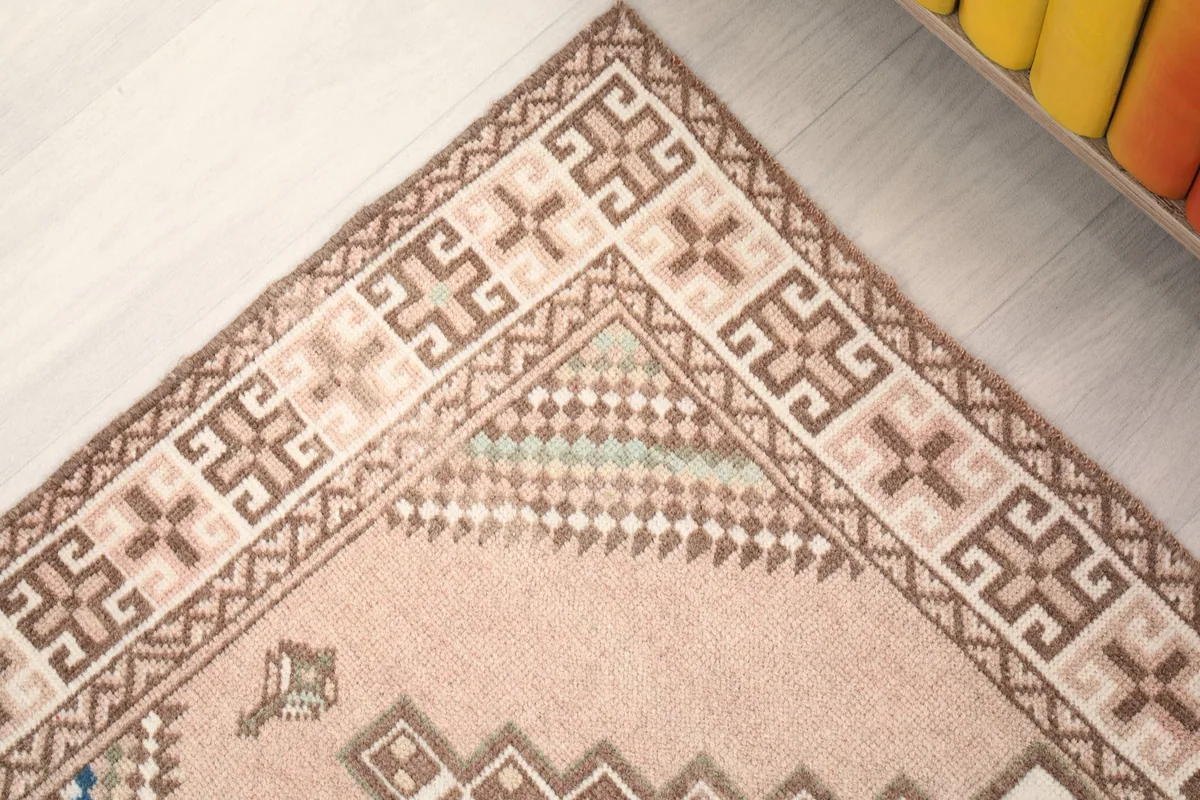 Corner detail of the rug's border with repeated geometric symbols