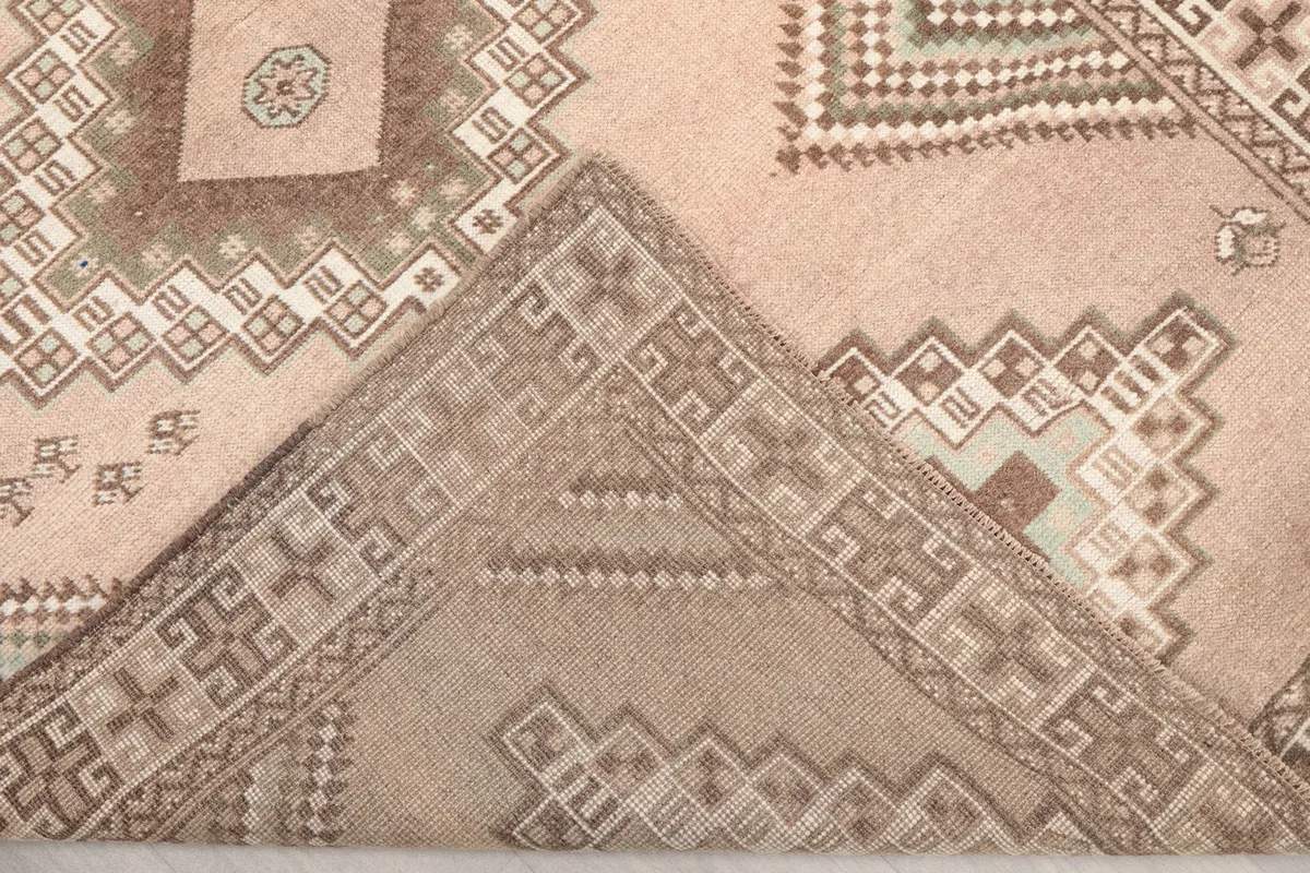View of the rug's reverse side, showing the cotton foundation and knotting
