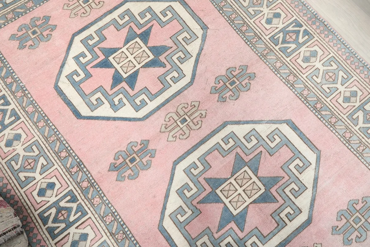 Overhead angle of the rug highlighting the central geometric medallions and surrounding motifs.