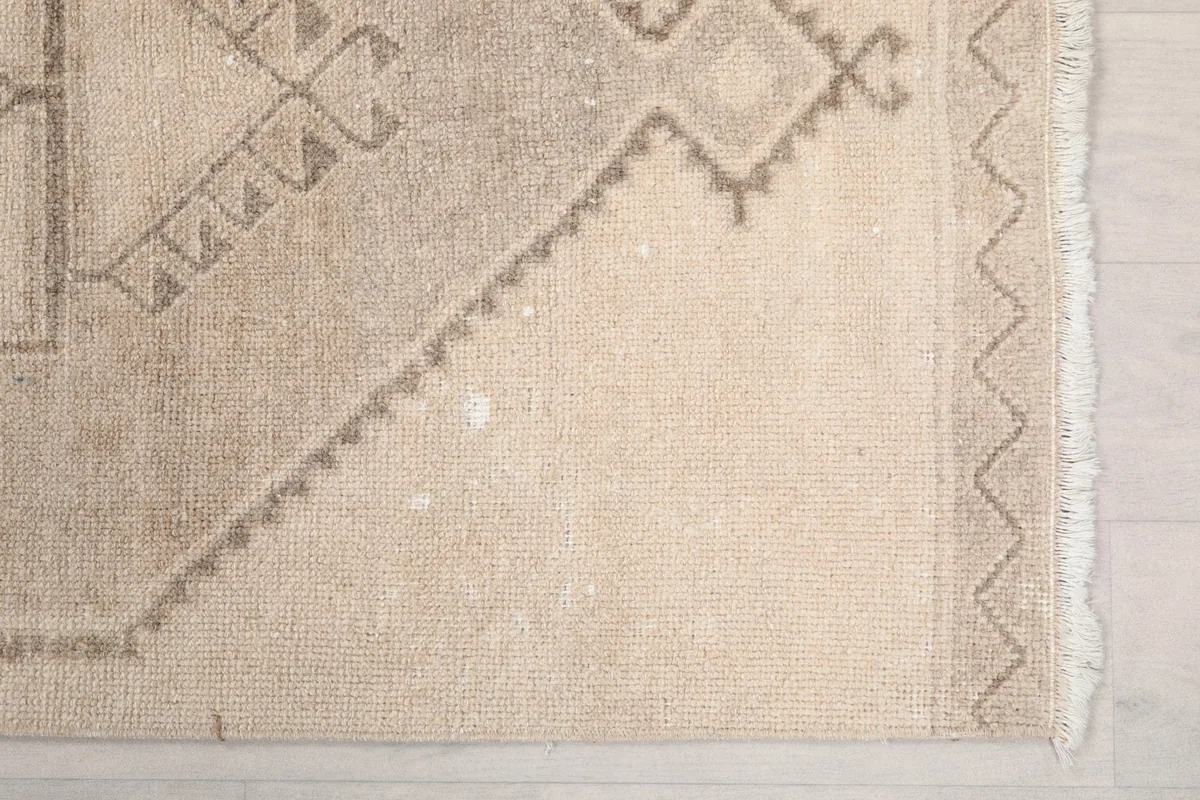 Detailed view of the rug's end, showcasing the geometric border and fringe
