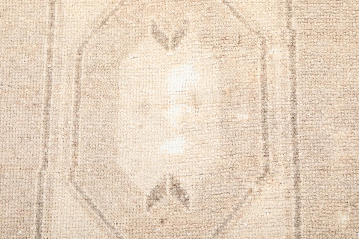 Extreme close-up of the rug's low pile and knot details within the central motif