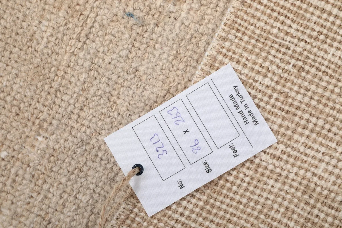 Close-up of the rug's back with a product tag showing dimensions in centimeters
