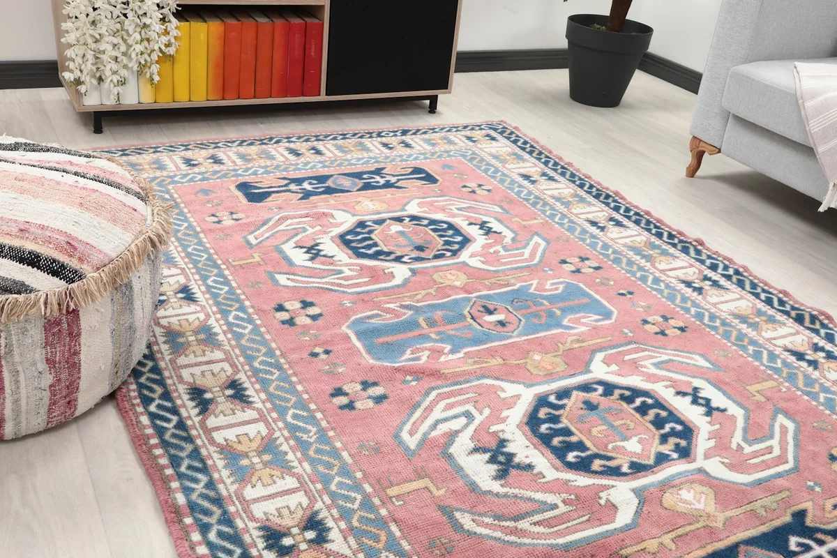 Close-up angle view of the rug's rose field and navy geometric patterns in a room setting