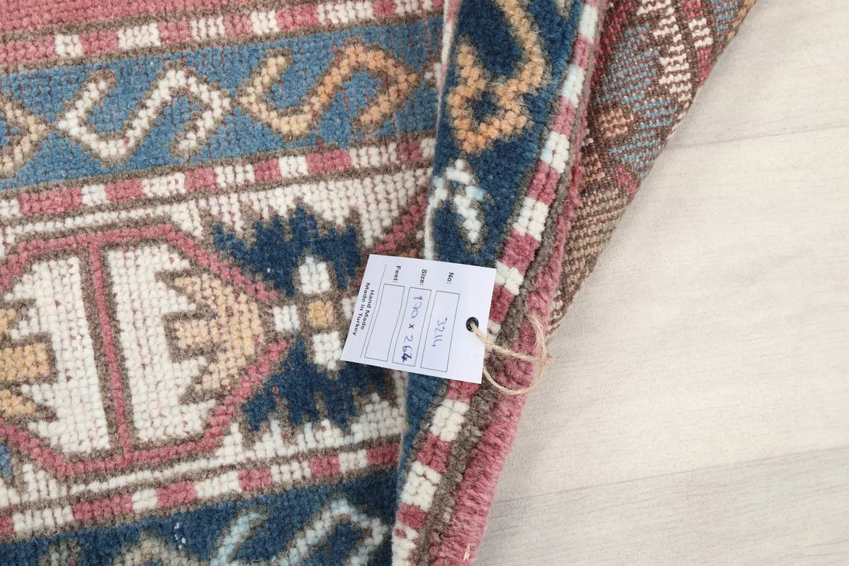 Close-up of the rug's edge with a product tag attached, indicating dimensions