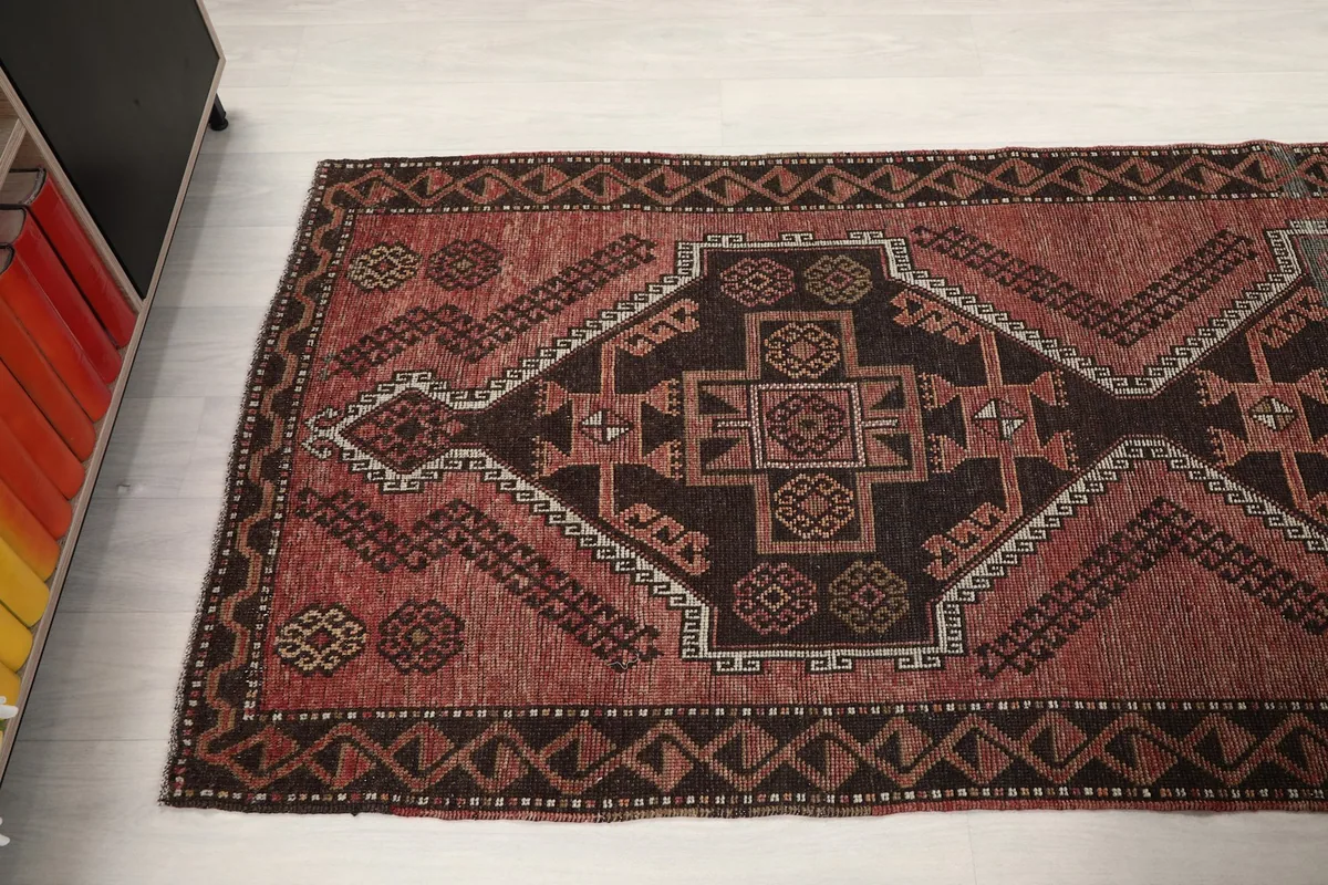 Angled view of the rug's patterns and colors, extending into the room